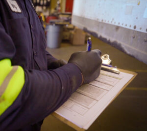 technician recording fleet data on a clipboard