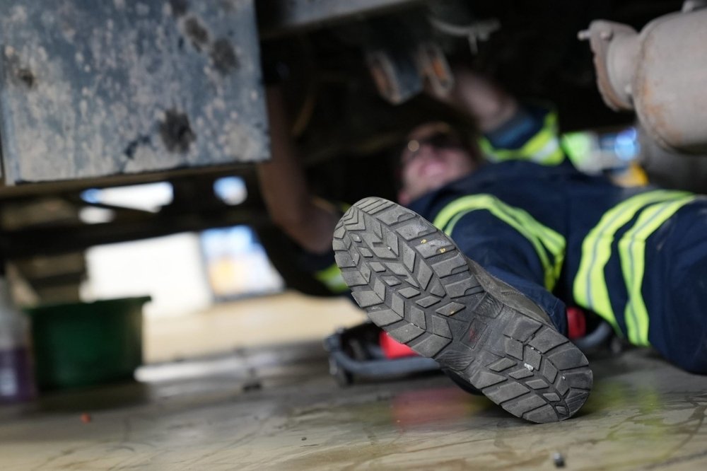 Amerit technician performing on site fleet repairs in a client’s garage.