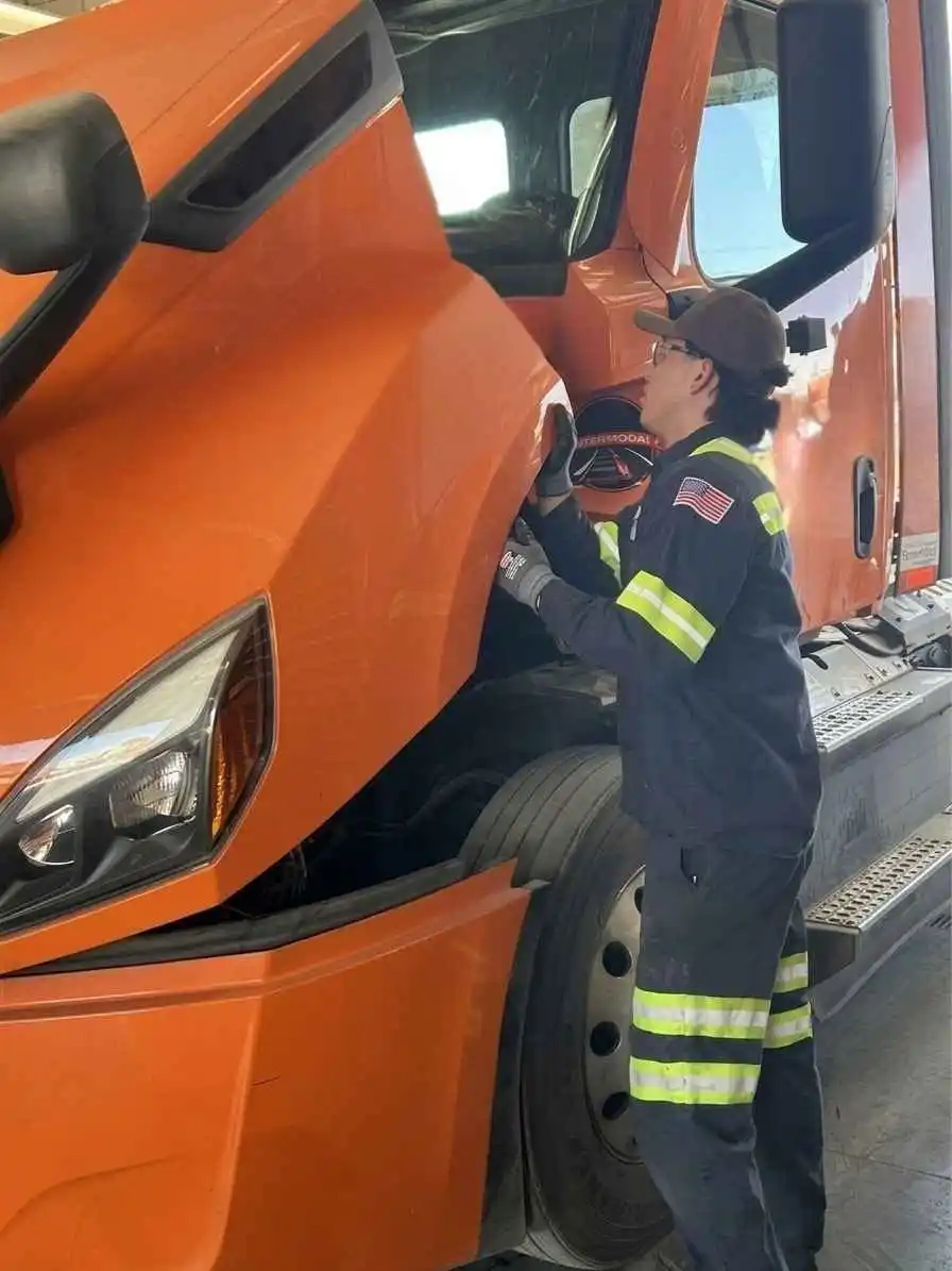 technician providing fleet services on tractor engine