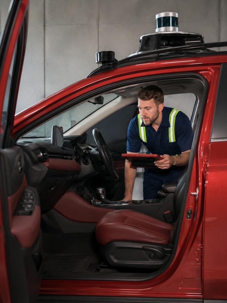 technician in autonomous vehicle completing inspection