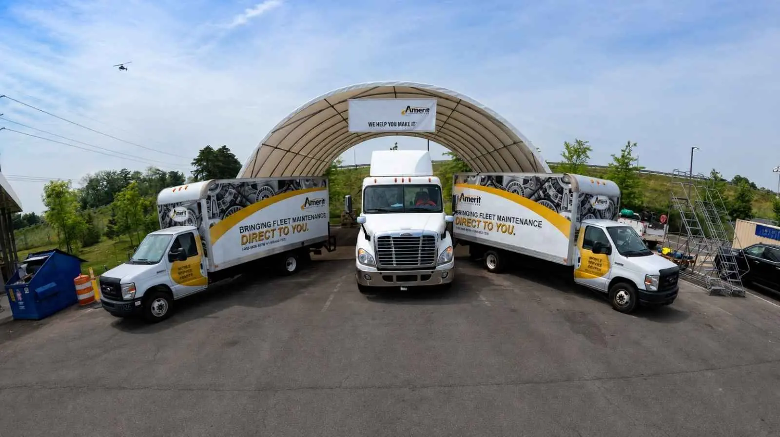 Canopy shelter and a conex storage unit for parts and tooling, creating a functional service environment for mobile fleet maintenance.