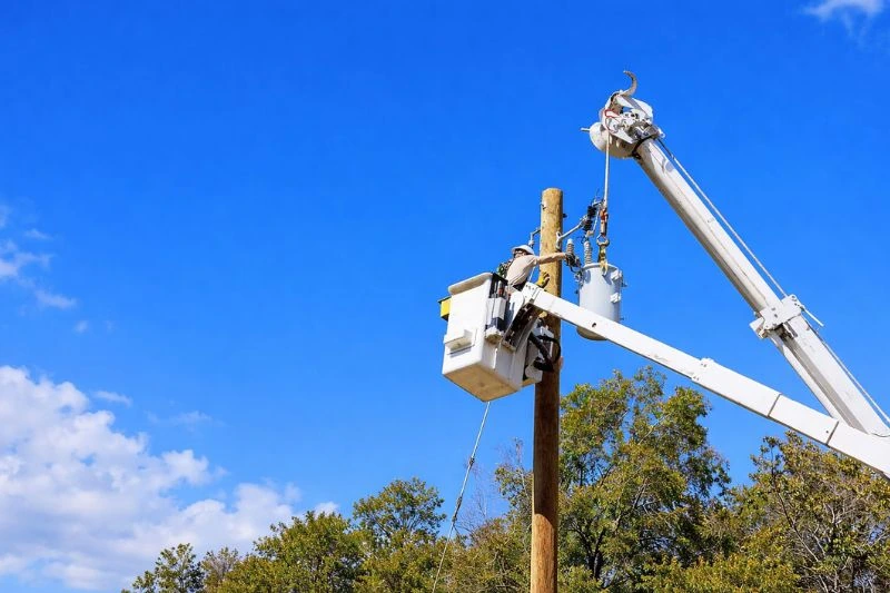 Telecom technician performing utility pole maintenance from bucket truck aerial lift.